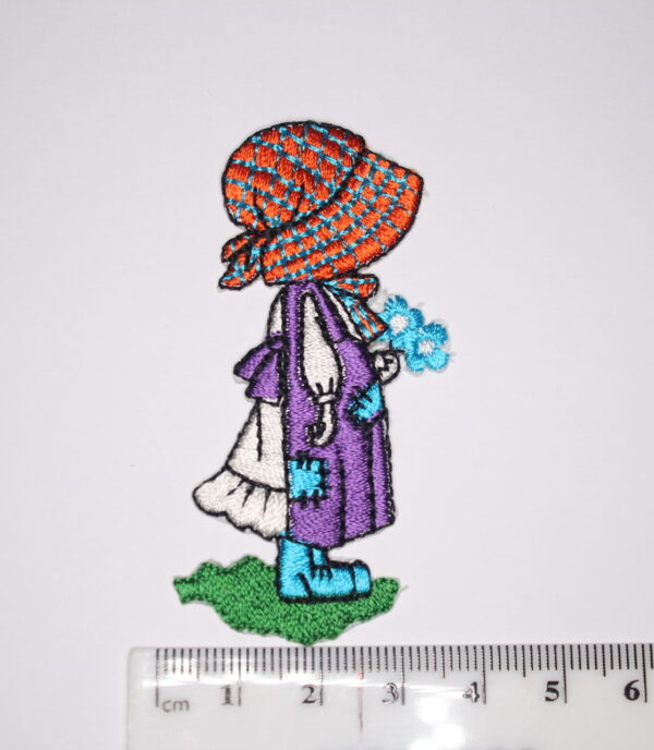 Girl with purple dress holding a bunch of flowers