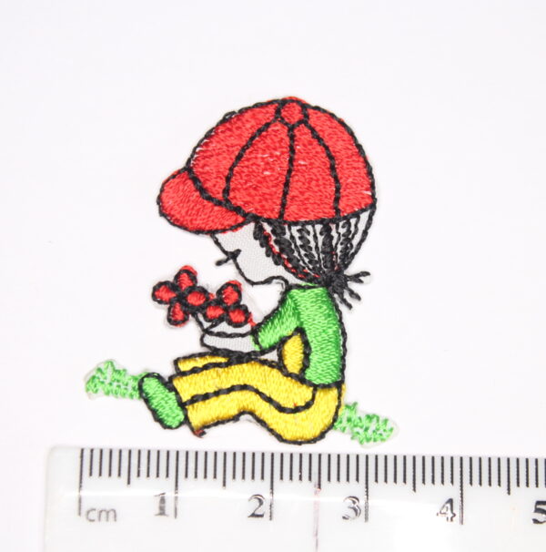 Girl sat with red hat holding a bunch of flowers